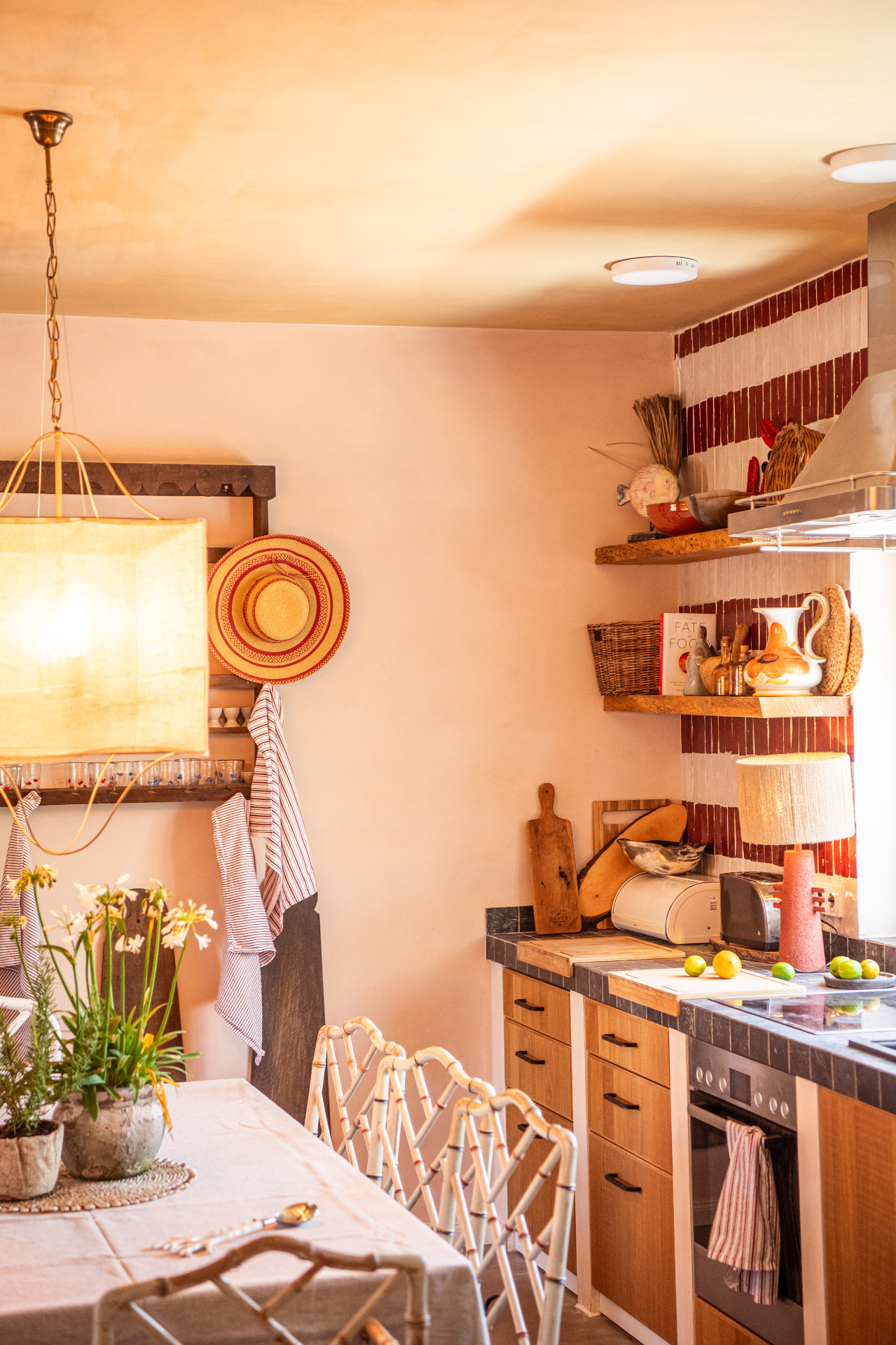 Dining table and kitchen with woven hat and pendant lamp